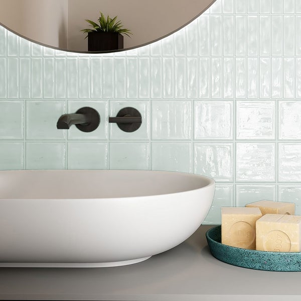 Modernes Badezimmer mit glänzenden Wandfliesen, Aufsatzwaschbecken und unterputz Armatur.
