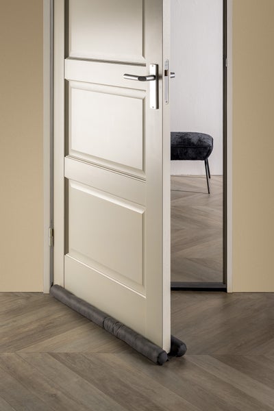 Offene Tür mit Zugluftstopper am Boden