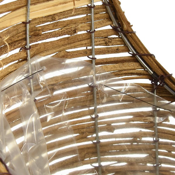 Detailansicht eines Insektenhotels mit Holzstreben und Folie