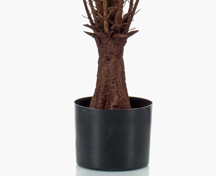 Nahaufnahme von künstlichen grünen Monstera-Blättern mit charakteristischen Blatteinschnitten und Löchern.