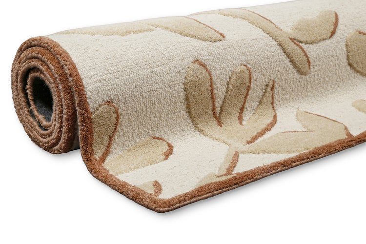 Eingerollter Teppich mit floralem Muster und variierender Florhöhe für einen Relief-Effekt.