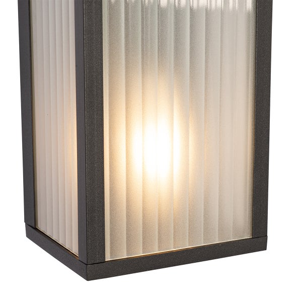 Nahaufnahme einer modernen rechteckigen Außenwandleuchte mit dunklem Metallrahmen und vertikal geripptem Milchglas, von innen beleuchtet.