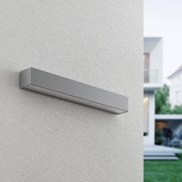Moderne, rechteckige Außenwandleuchte aus Metall an einer verputzten Hauswand.