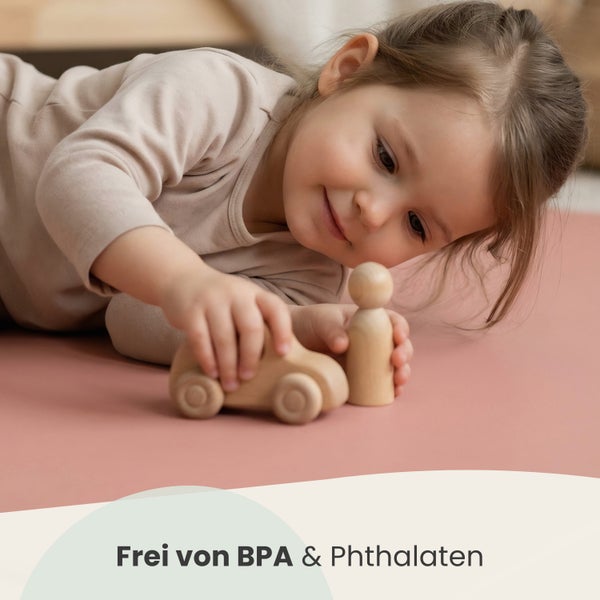 Ein Kind spielt mit einem Holzauto und einer Holzfigur auf einer Spielmatte, frei von Bisphenol A und Phthalaten.