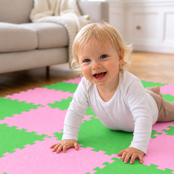 Kleinkind krabbelt auf einer bunten Puzzlematte aus Schaumstoff im Wohnzimmer