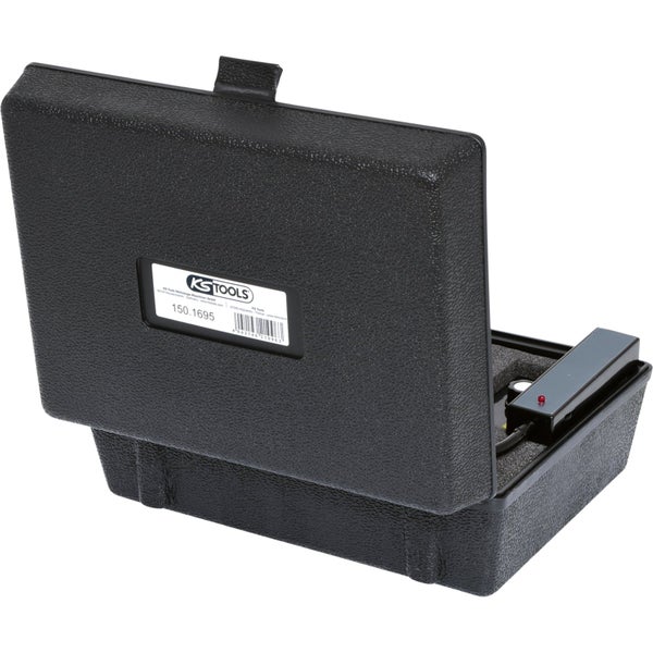 Ein Mechaniker mit Kopfhörern diagnostiziert einen Automotor mit einem elektronischen Diagnosegerät.