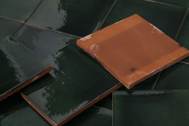 Nahaufnahme von dunkelgrünen, glänzenden Keramikfliesen mit quadratischer Form