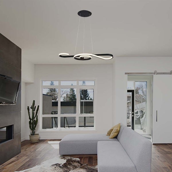 Modernes Wohnzimmer mit geschwungener LED-Pendelleuchte über einem grauen Sofa.