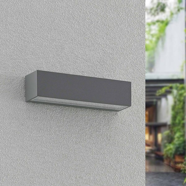 Moderne rechteckige Außenwandleuchte aus Metall in Anthrazit an einer strukturierten Hauswand montiert.