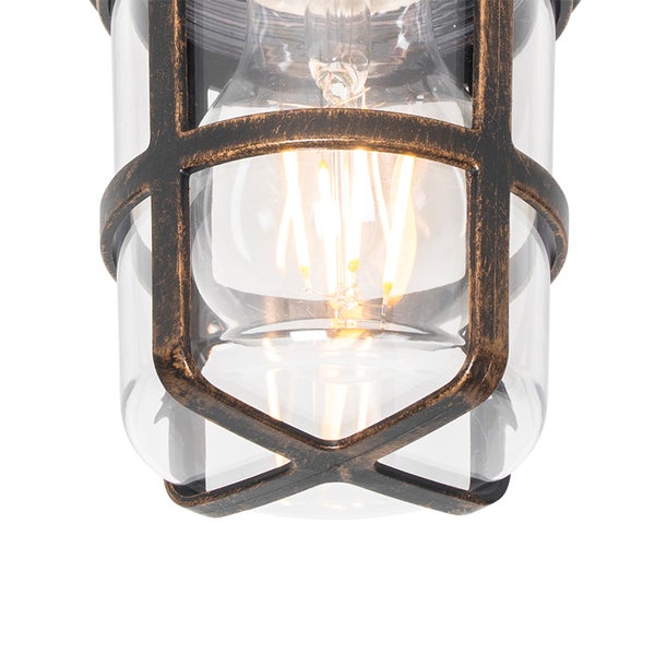 Außenleuchte mit Metallkäfig in Antik-Optik, klarem Glaszylinder und eingeschaltetem LED-Filament-Leuchtmittel.