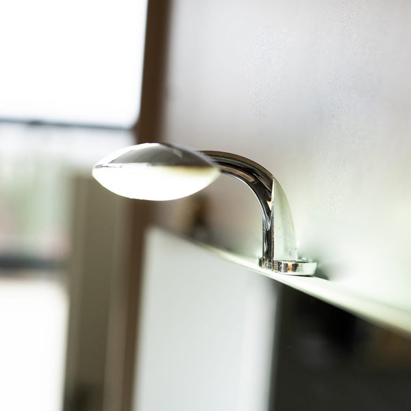 Verchromte LED-Spiegelleuchte mit ovalem Kopf zur Montage auf Badezimmerschränken oder Spiegeln.