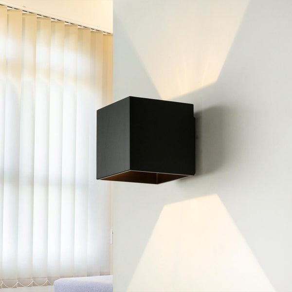 Moderne quadratische Wandleuchte in Würfelform für Up and Down Lichteffekt an einer Innenwand.