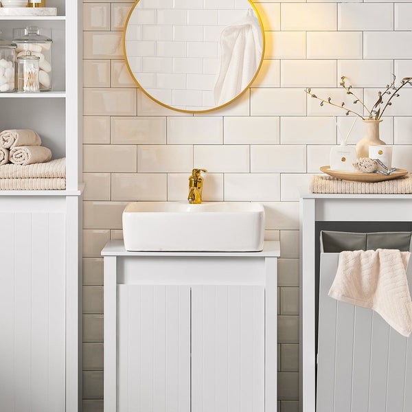 Helles Badezimmer mit Waschbecken, Unterschrank, Spiegel und Aufbewahrungsschränken für ein organisiertes Ambiente