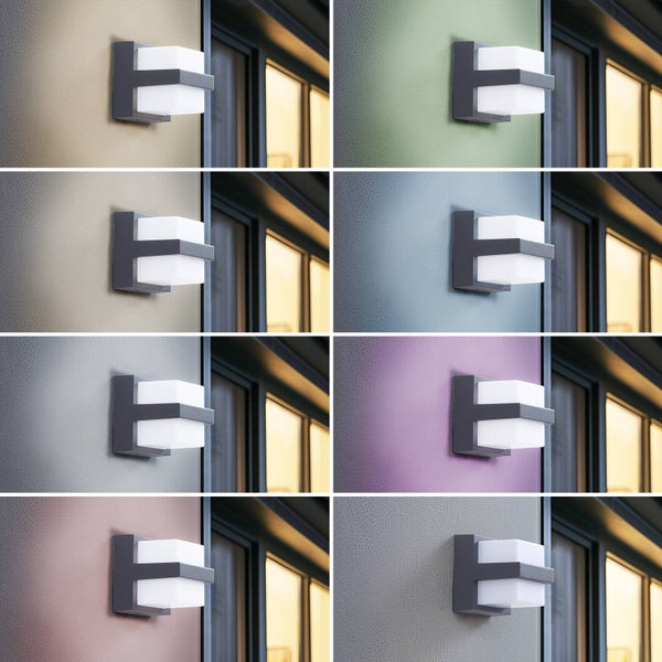 Moderne LED Außenwandleuchte mit dunkelgrauem Metallrahmen und weißen Diffusoren, montiert an einer strukturierten Fassade neben einem Fenster.