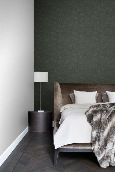 Schlafzimmer mit Vliestapete mit Zebramuster an einer Wand, gepolstertem Bett, Nachttisch und Stehleuchte in eleganter Wohnatmosphäre.