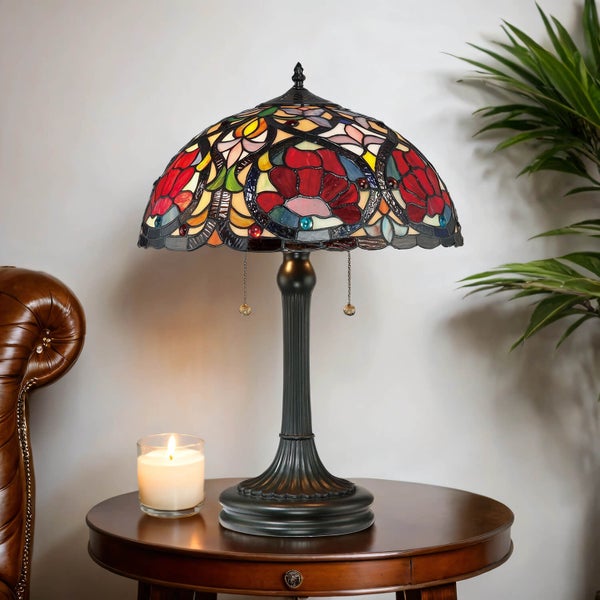 Tischleuchte mit Buntglas-Lampenschirm im Tiffany-Stil auf einem Holztisch