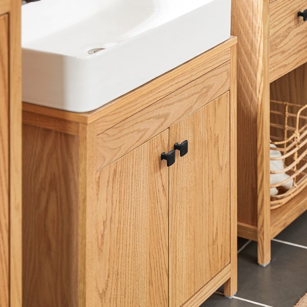 Detailansicht eines Waschtischunterschranks aus Holz mit schwarzem Griff