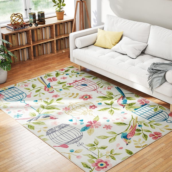 Rechteckiger Teppich mit Motiven von Vögeln, Blumen und Vogelkäfigen in einem hellen Wohnzimmer auf Holzboden.