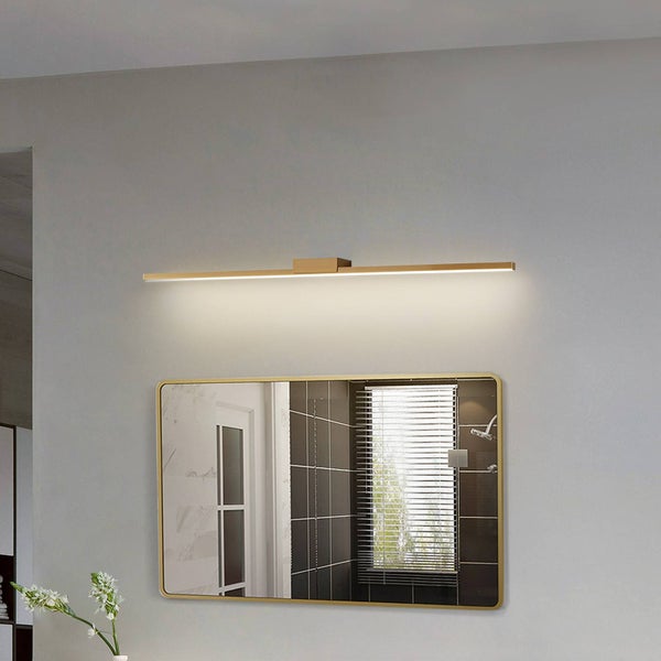 Moderne, lange LED-Spiegelleuchte in Gold über einem abgerundeten Wandspiegel in einem hellen, organisierten Badezimmer.