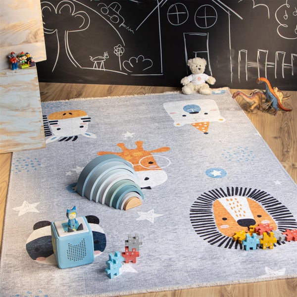 Kinderspielteppich mit Tiermotiven und Sternen in einem Kinderzimmer mit verschiedenen Spielzeugen auf dem Boden