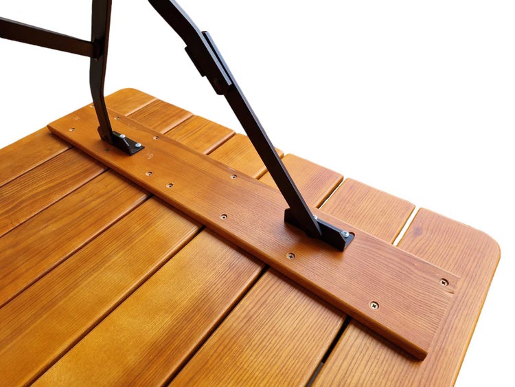 Detailansicht der Unterseite eines Holztisches mit schwarzen Metallbeinen, die an Holzlatten verschraubt sind.
