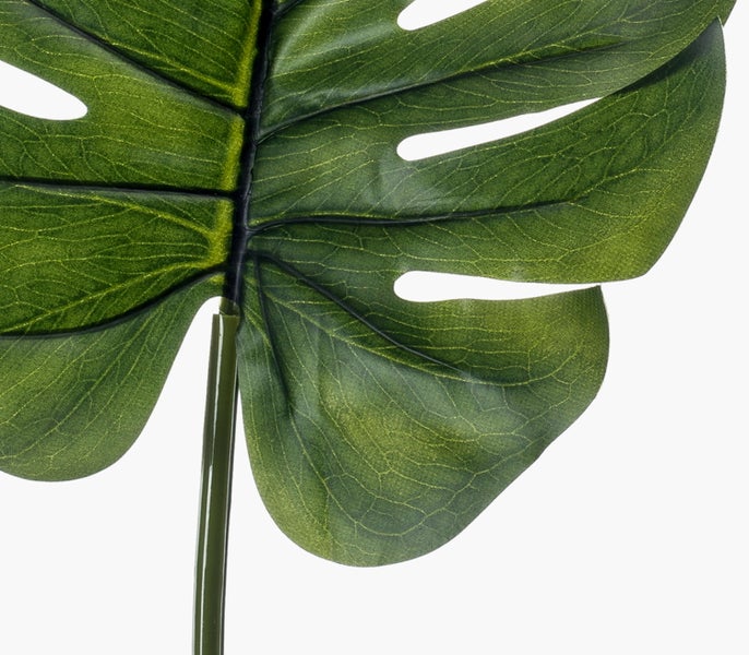 Künstliches Monstera-Blatt mit charakteristischen Einschnitten und sichtbaren Blattadern an einem langen Stiel.
