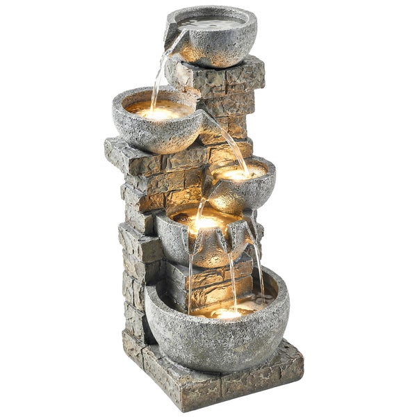 Fünfstufiger Kaskadenbrunnen in Steinoptik mit LED-Beleuchtung vor einem Holzzaun, 80 Zentimeter hoch, mit einer Katze in einem Garten mit Blumen.