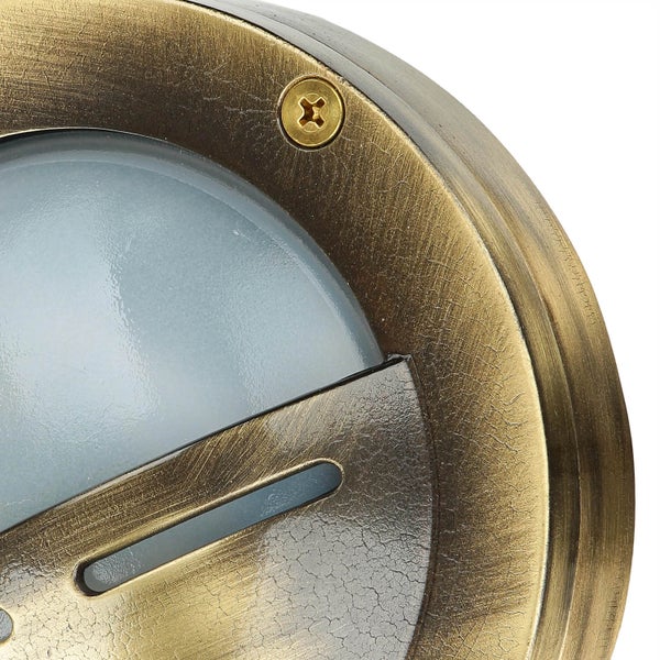 Detailaufnahme einer runden, messingfarbenen Leuchte mit Schraube