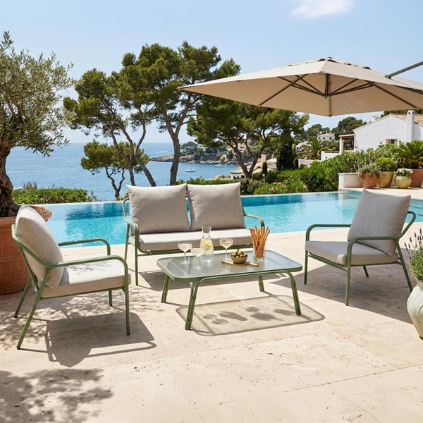 Moderne Gartenlounge mit Sofa, zwei Sesseln und Couchtisch aus Metall auf einer Terrasse am Pool.