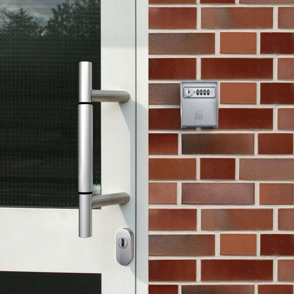 Tür mit Türgriff und Schlüsselsafe an einer Backsteinmauer