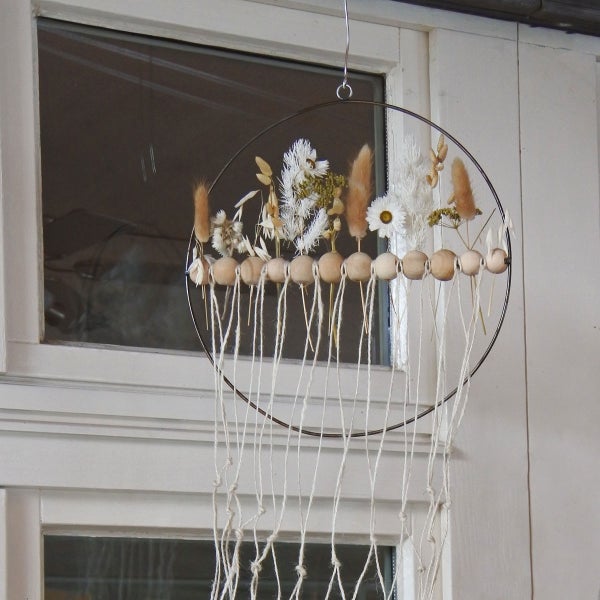 Dekorativer Trockenblumenring mit Holzkugeln und Schnüren als Wanddeko.