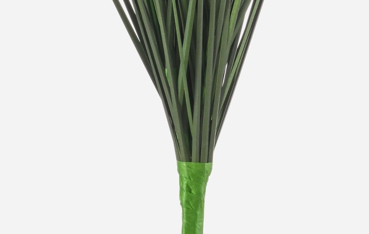 Künstliche Gerbera mit rosa Blütenblättern und gelber Mitte an einem grünen Stiel.