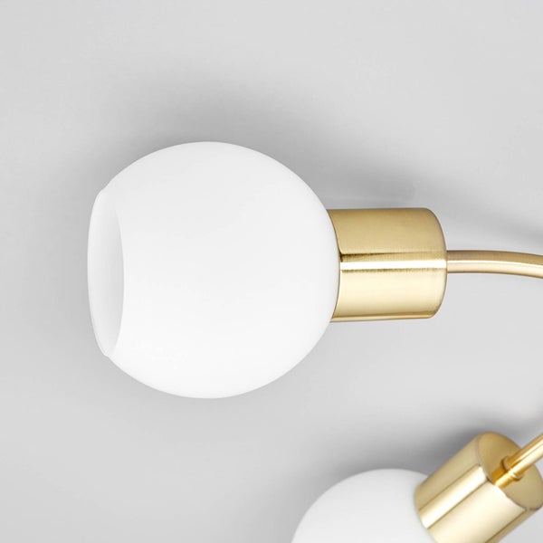 Nahaufnahme einer Deckenleuchte mit goldenen Details und runden, weißen Lampenschirmen