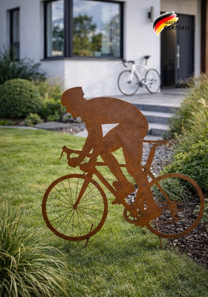 Gartenstecker aus Edelrost in Form eines Radfahrers, platziert auf einer Rasenfläche im Garten.
