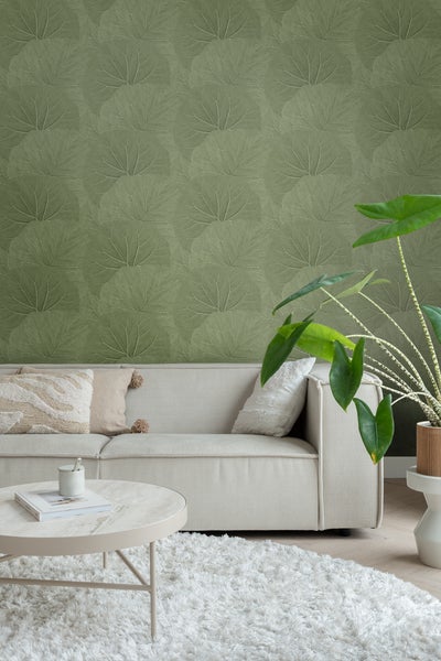 Wohnzimmer mit grüner Blättertapete, Sofa, Couchtisch und Teppich