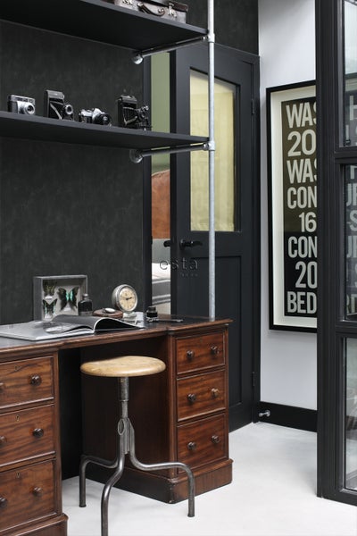 Szene mit Schreibtisch, Hocker, Regalen und Dekorationsartikeln in einem Arbeitszimmer