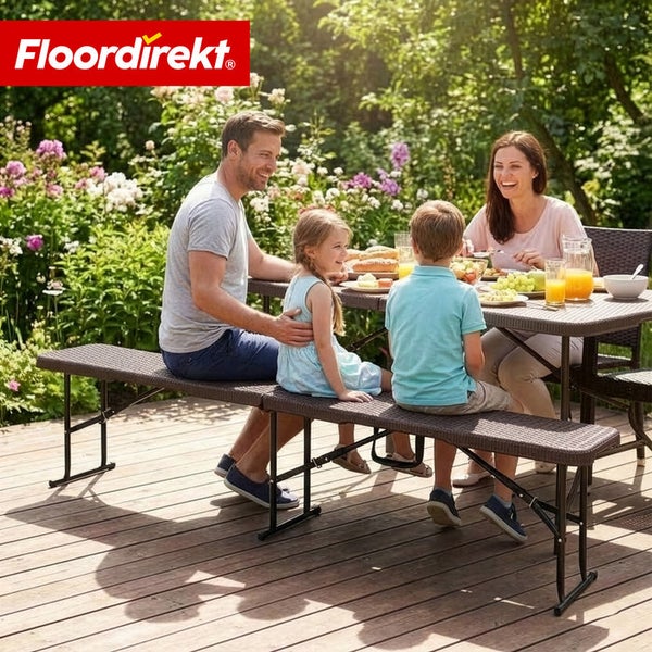Familie sitzt an einem Gartentisch mit Rattanoberfläche auf einer passenden Bank. Floordirekt Logo.