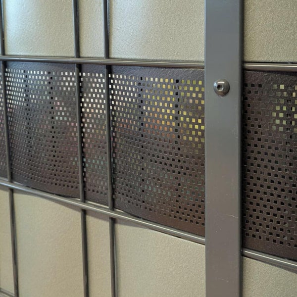 Detailansicht eines perforierten Metallgitters mit Rahmen