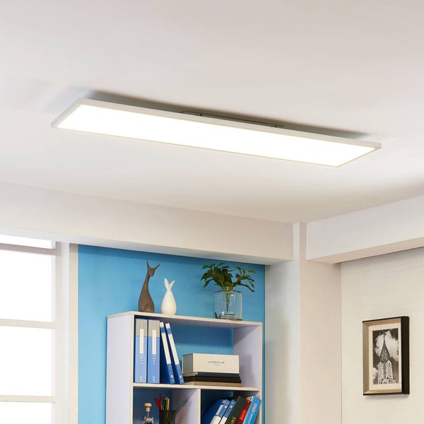 Rechteckiges LED-Deckenpanel an einer Zimmerdecke in einem hellen Raum über einem Bücherregal.
