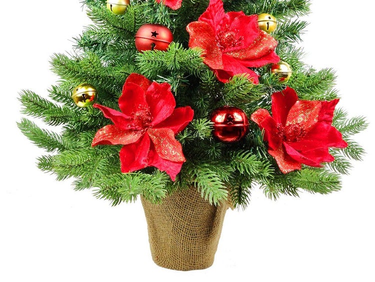 Künstlicher Weihnachtsbaum in Jutetopf geschmückt mit roten Weihnachtsblumen und Glocken