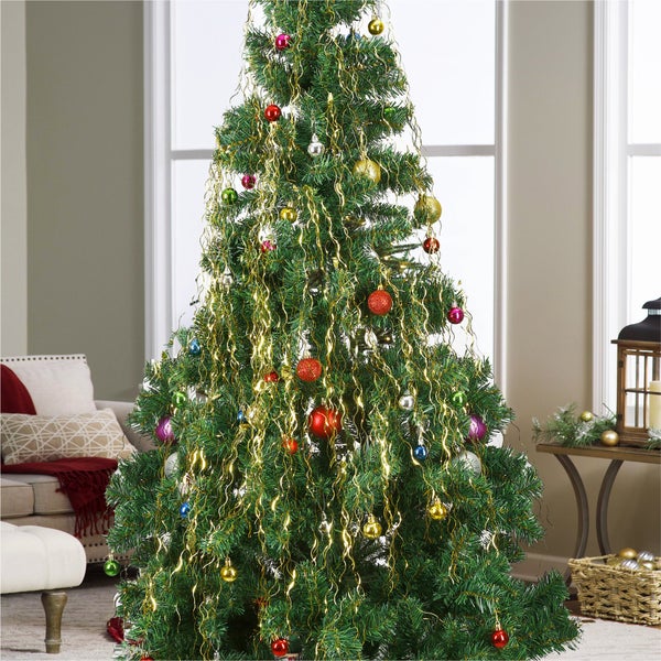 Geschmückter Weihnachtsbaum mit Christbaumschmuck und Lametta im Wohnzimmer.