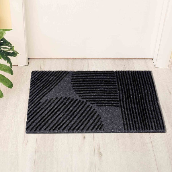 Schmutzfangmatte mit geometrischem Muster vor einer Tür