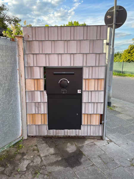 Briefkastenanlage in einem Zaun integriert