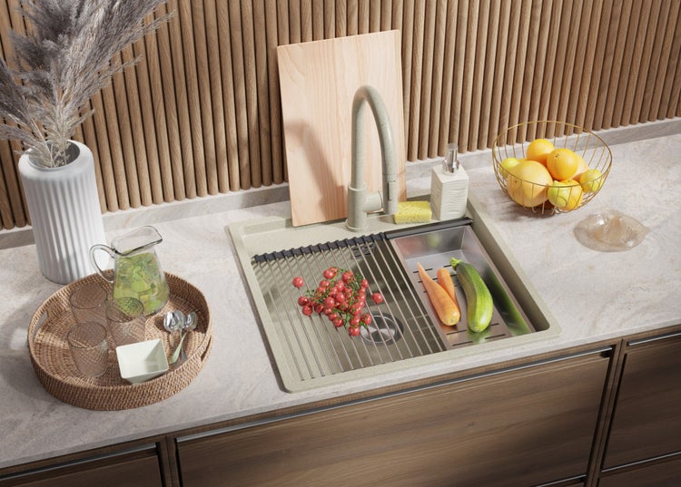 Küchenspüle aus Edelstahl mit Abtropfgestell, Armatur und Lebensmitteln auf einer Küchentheke.