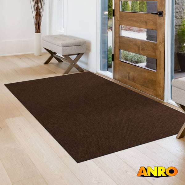 Dunkelbraune Schmutzfangmatte in hellem, modernen Flur vor Holztür mit Glaseinsätzen. ANRO Logo.