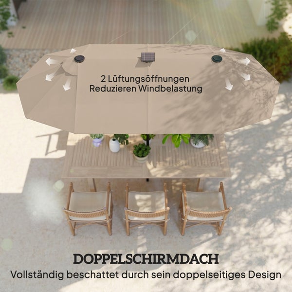 Rechteckiger Sonnenschirm mit LED-Beleuchtung über einem Loungesofa aus Rattan auf einer beleuchteten Terrasse bei Dämmerung.