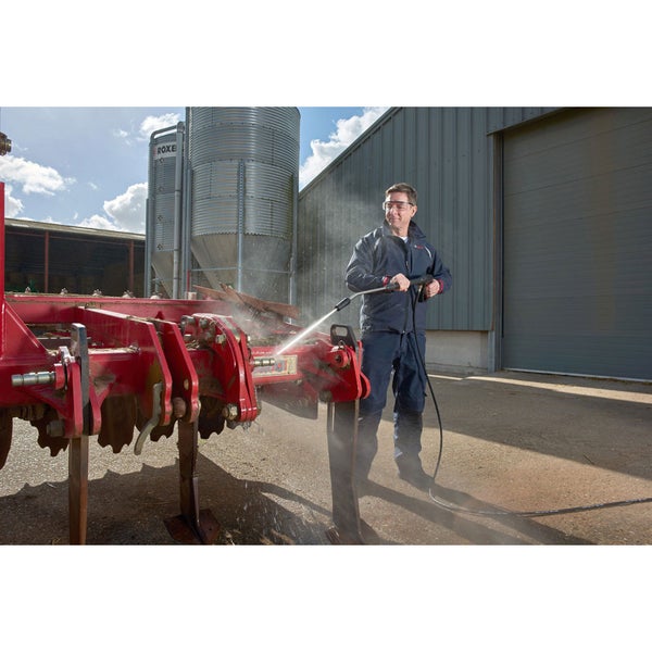 Mann reinigt Auto mit einem Hochdruckreiniger