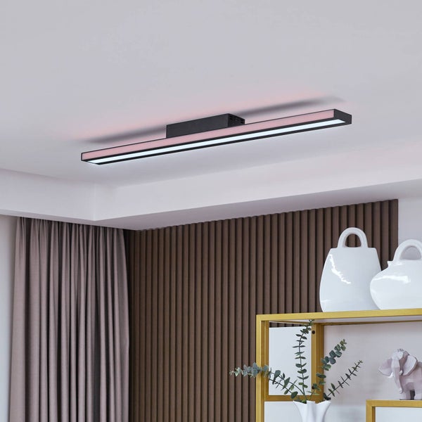Moderne LED-Deckenleuchte in Schwarz, schlankes lineares Design mit weißem Hauptlicht und pinkfarbenem RGB-Backlight in einem Wohnraum.