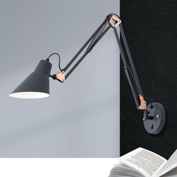 Wandleuchte mit verstellbarem Gelenkarm und Leuchtenkopf im industriellen Stil montiert an einer Wand über einem aufgeschlagenen Buch