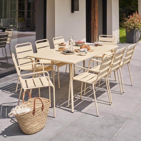 Moderne beige Garten-Essgruppe aus Metall mit großem rechteckigem Tisch und acht Stühlen auf einer Steinterrasse.